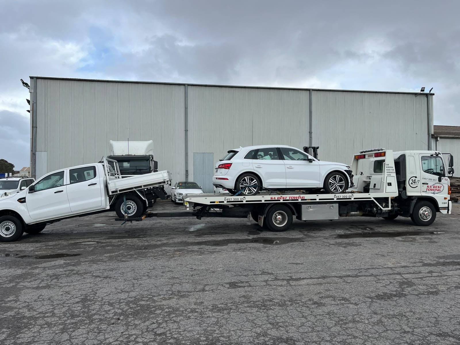 White Audi Q5 on the tray and a Ford Ranger on the rear lift