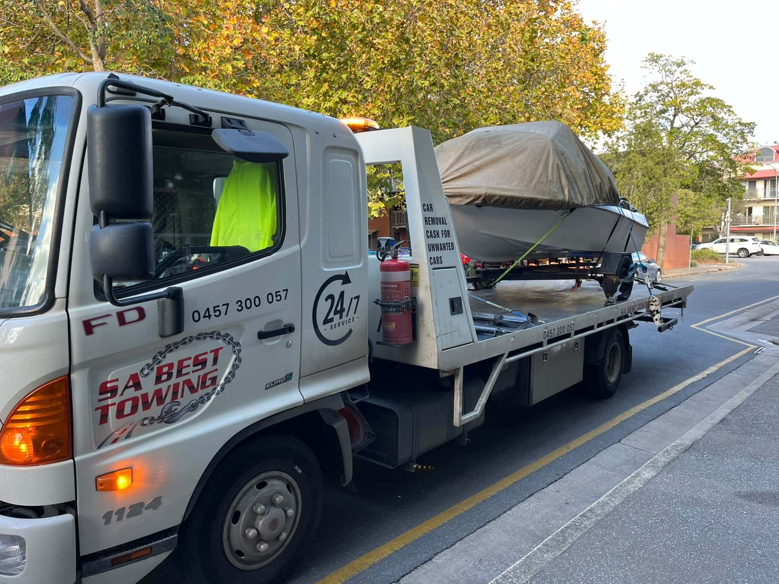 Boat trailer tied down at the rear of the SA Best Towing tilt tray with a green strap over the hull and a fire extinguisher on the headboard