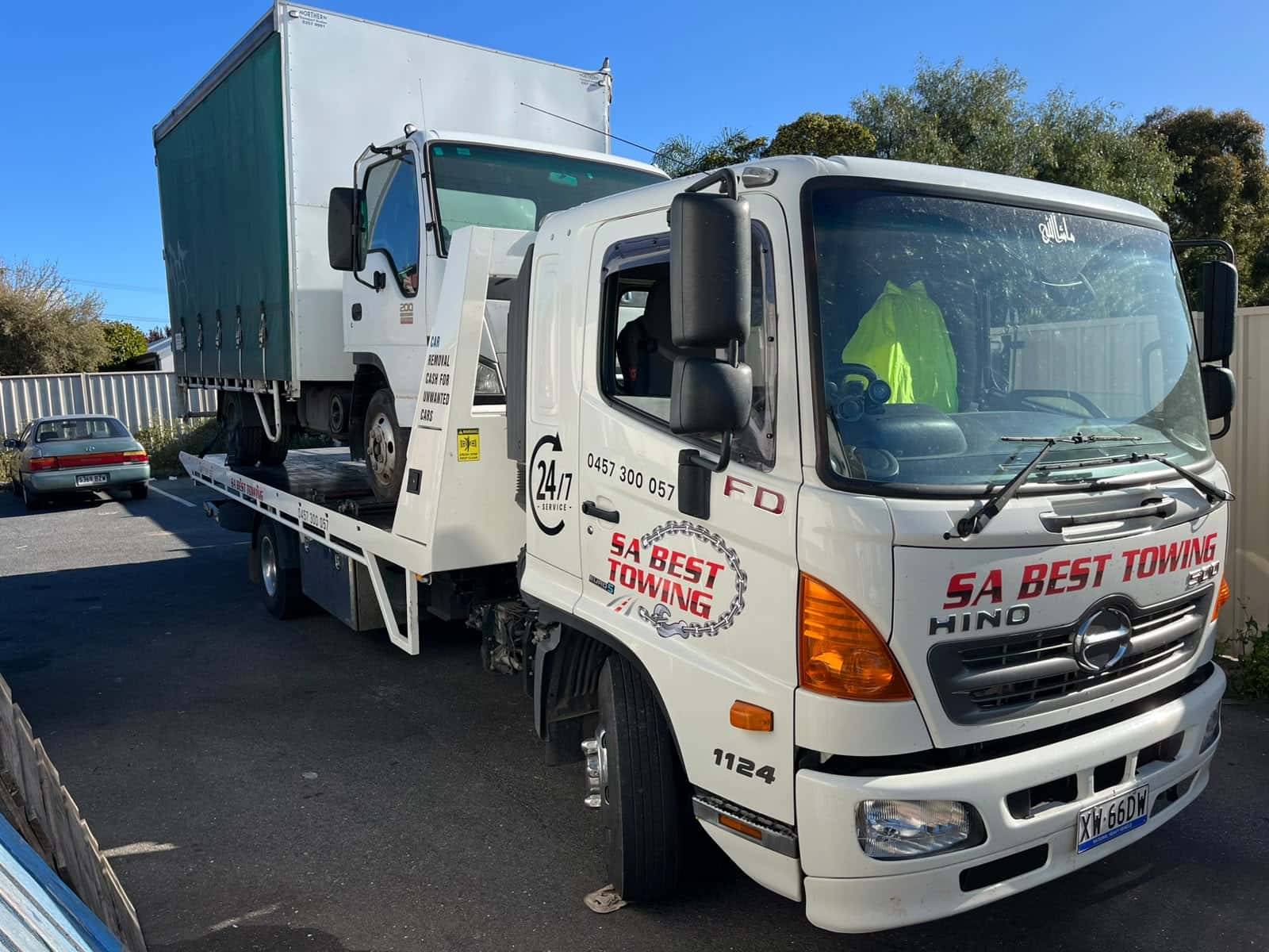 SA Best Towing Hino carrying an Isuzu curtain-side light truck