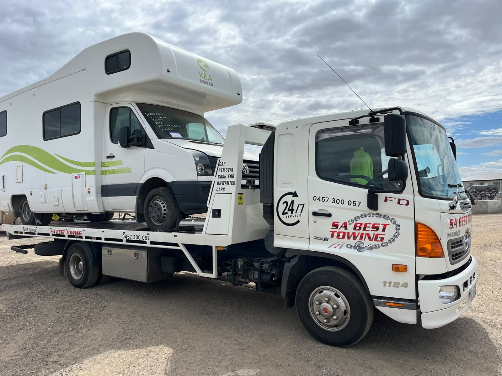 White motorhome with a green stripe on the SA Best Towing tilt tray