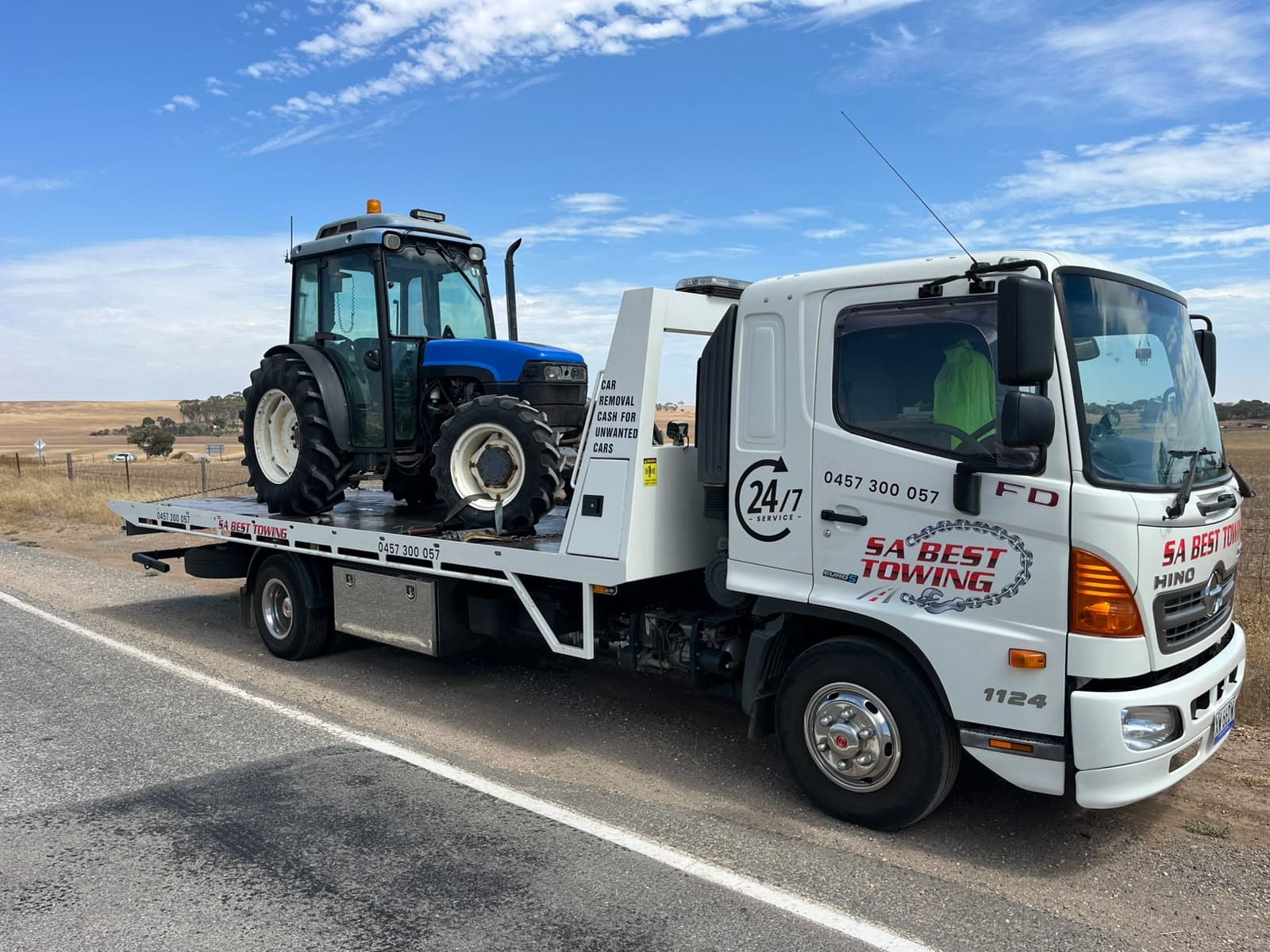 Blue New Holland tractor on the SA Best Towing tilt tray