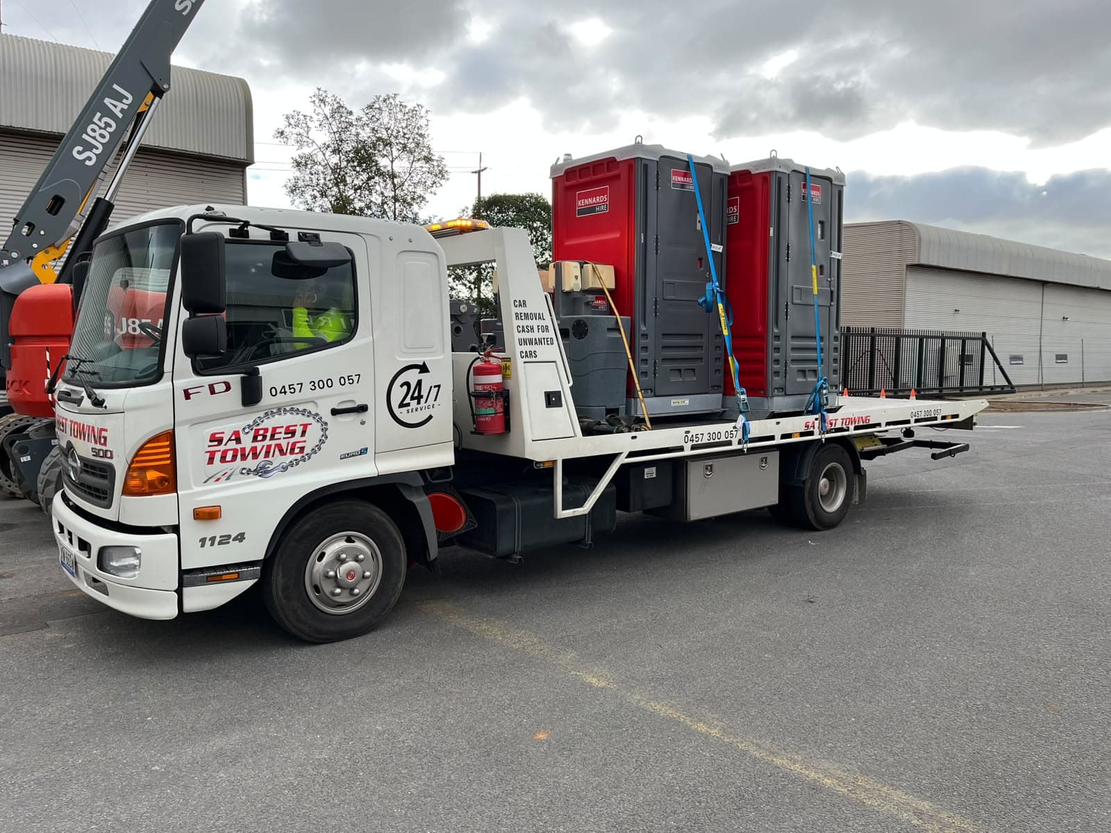 Two portable site toilets strapped upright on the tilt tray