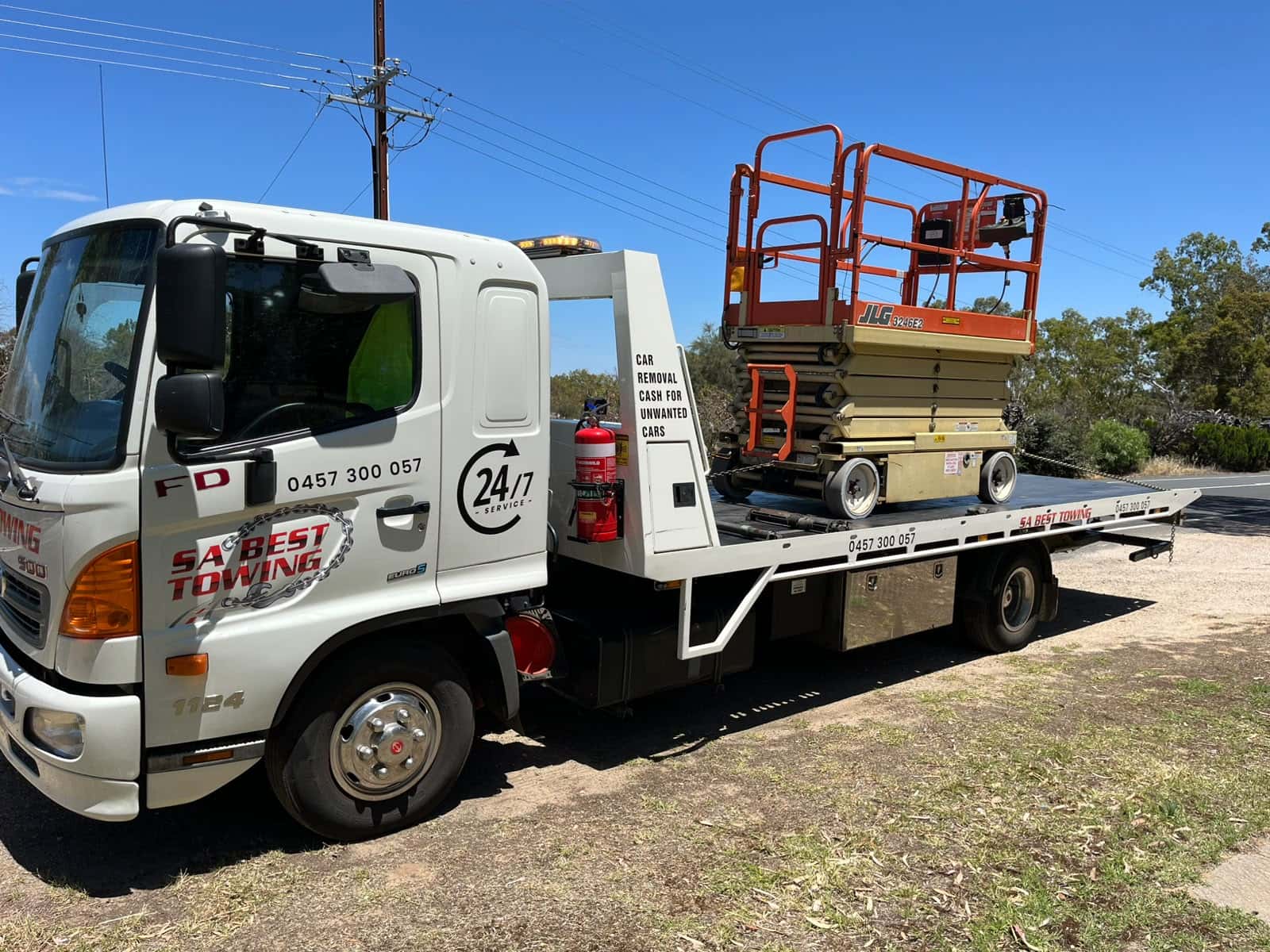 Front three-quarter view of the SA Best Towing Hino carrying a scissor lift